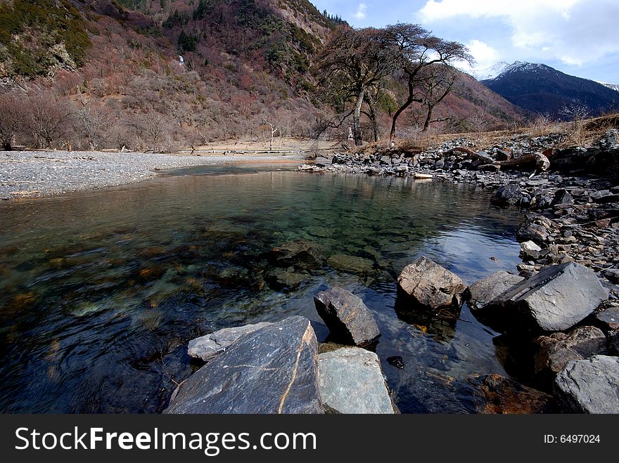 Plateau on the river, the water is very clear, is far from tall trees and dry.Photographs the place is the Chinese Sichuan province Xiaojin County's Mt. Siguniang mountain