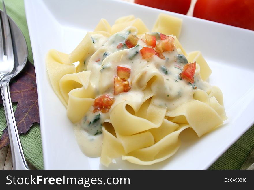 A meal of fresh pasta with tomatoes and cheese sauce