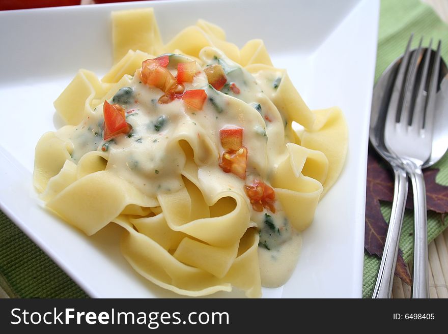 A meal of fresh pasta with tomatoes and cheese sauce