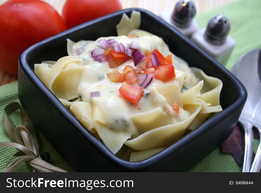 A meal of fresh pasta with tomatoes and cheese sauce