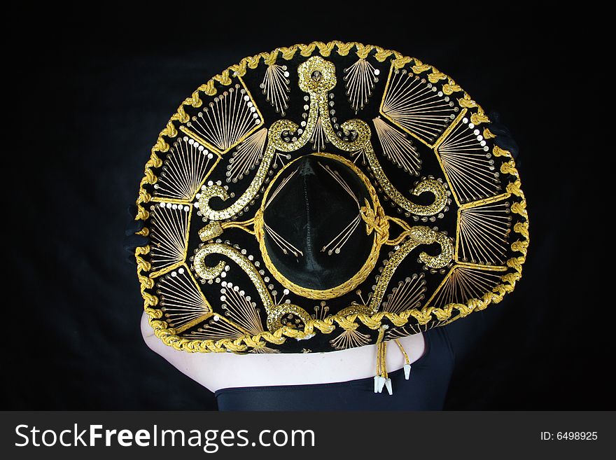 Woman wearing a mexican sombrero over dark background