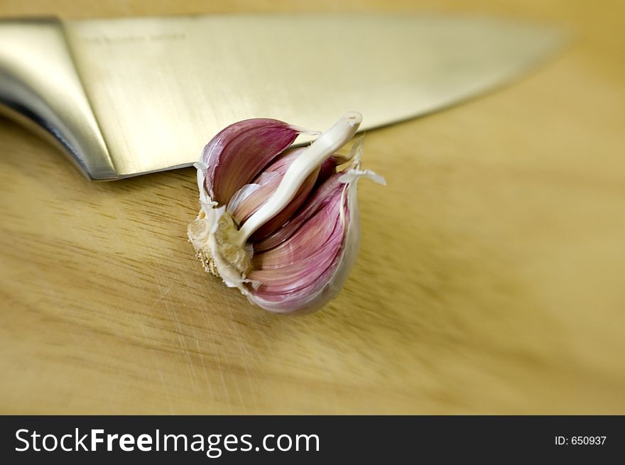 Chef's Knife and garlic on wooden chopping board