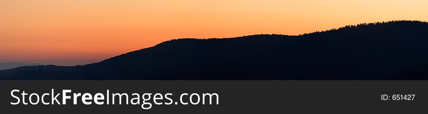 The abstract silhouette of a mountain ridge against the sunset sky - Smoky Mountains Nat. Park, USA. A stitched panorama of ~26 Megapixels. The abstract silhouette of a mountain ridge against the sunset sky - Smoky Mountains Nat. Park, USA. A stitched panorama of ~26 Megapixels.