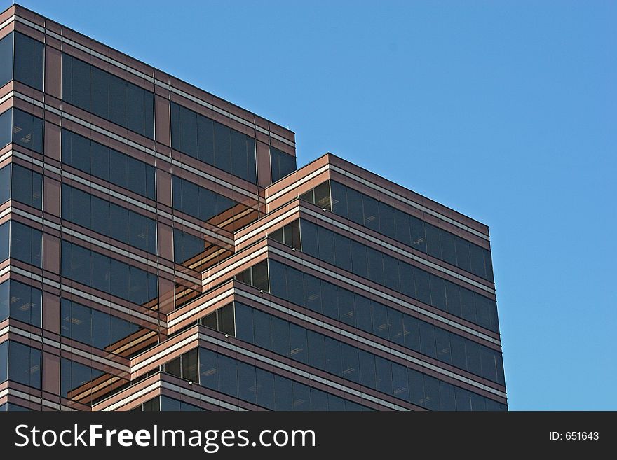 Brick and Glass tower with terraces against sky. Brick and Glass tower with terraces against sky