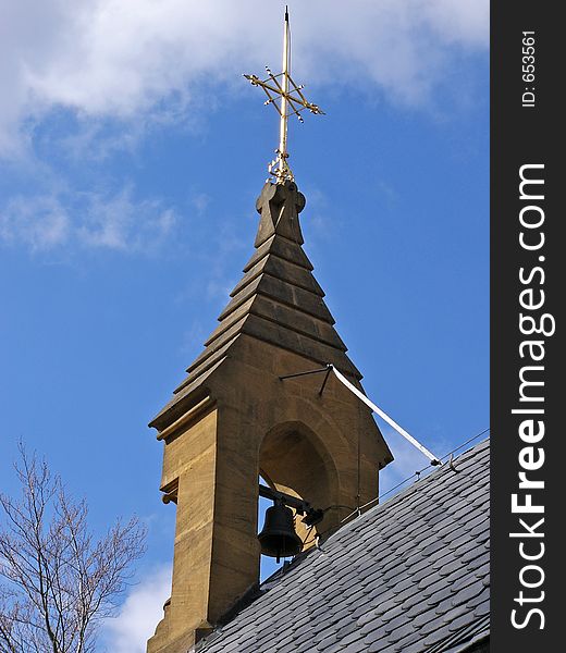 Pilgrimage chapel tower with church bell and golden cross on the rooftop