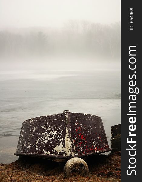 Boat upside down on the edge of a misty pond. Boat upside down on the edge of a misty pond