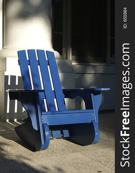 Blue chair on porch with shadow.