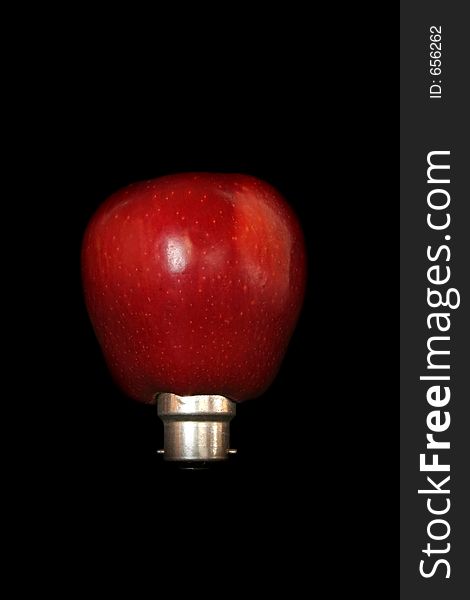 Image of an apple plugged into a light bulb - conceptual energy. Image of an apple plugged into a light bulb - conceptual energy