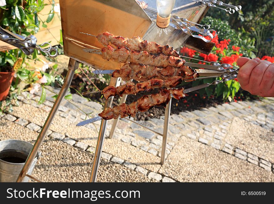 Hand with roasted shish kebab.