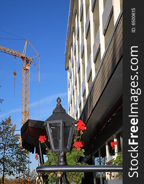 Street lamp, crane and building against blue sky. Street lamp, crane and building against blue sky.