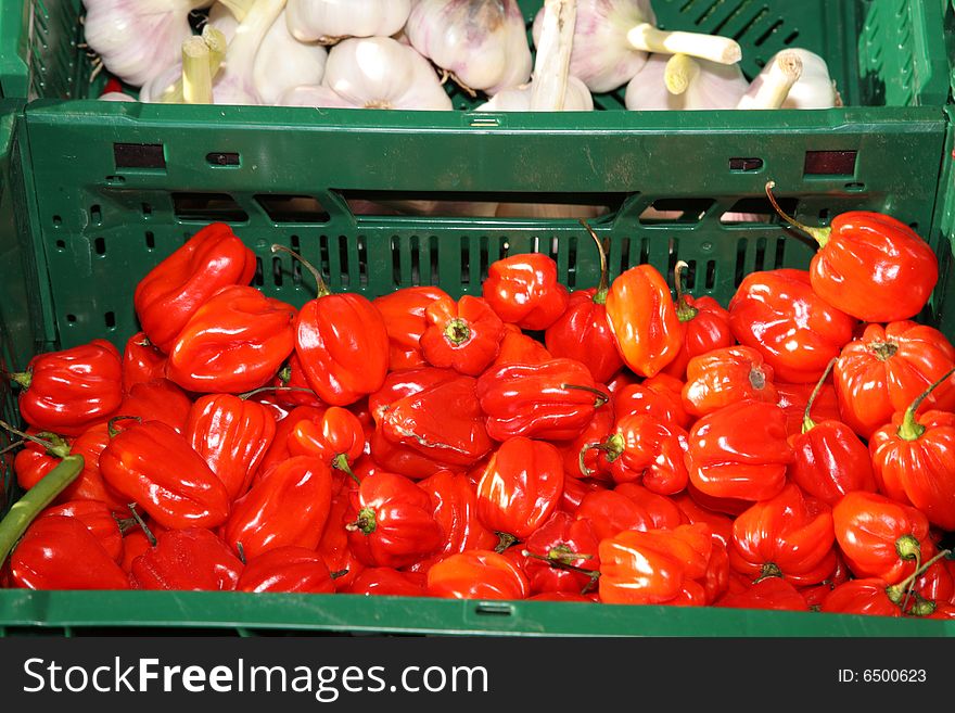 Red pepper and garlic in green boxes on the fair. Red pepper and garlic in green boxes on the fair.