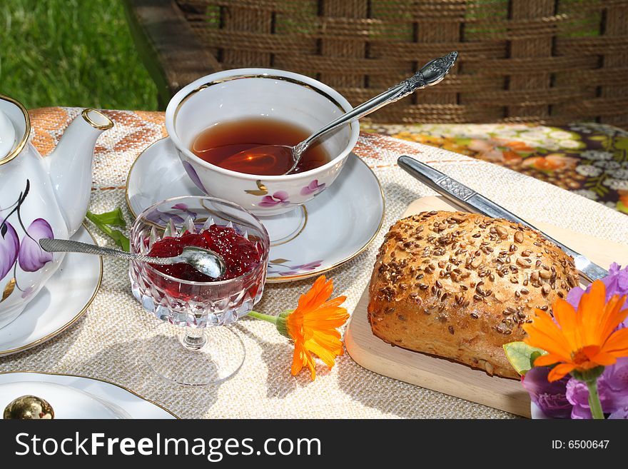 Cup of tea and simple food on a table in a garden. Cup of tea and simple food on a table in a garden.