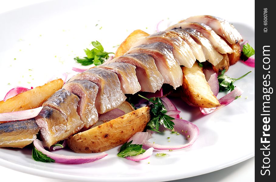 Sliced Fish Served with Baked Potatoes, Green and Onion. Isolated on White Background. Sliced Fish Served with Baked Potatoes, Green and Onion. Isolated on White Background