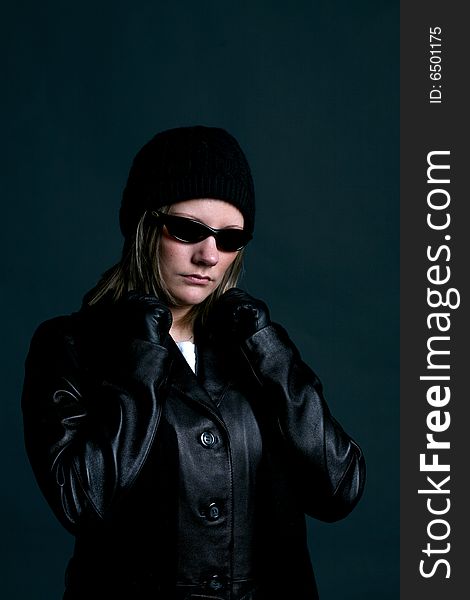 Mysterious woman in dark sunglasses, and black leather. Mysterious woman in dark sunglasses, and black leather.