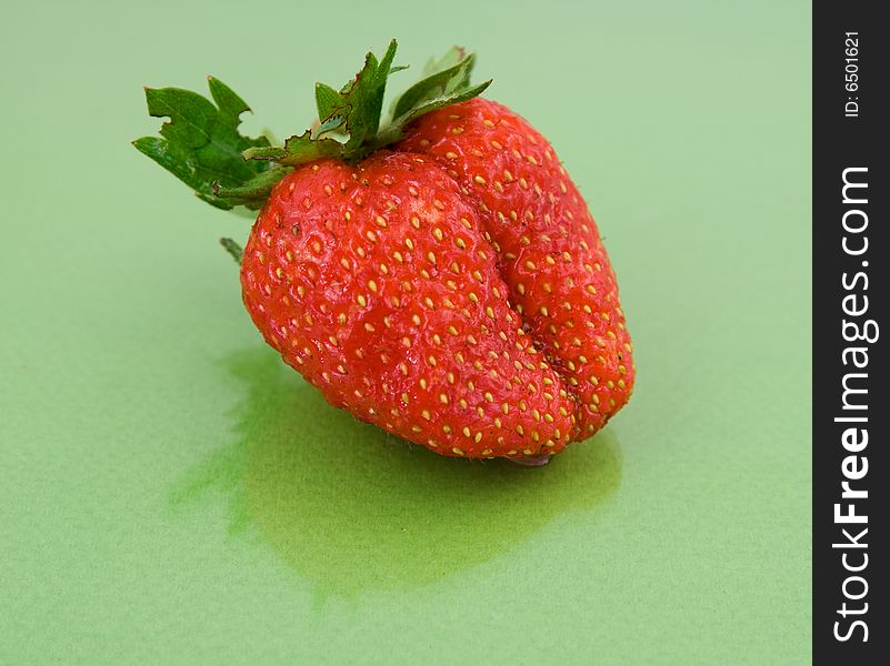 Red strawberry isolated on green