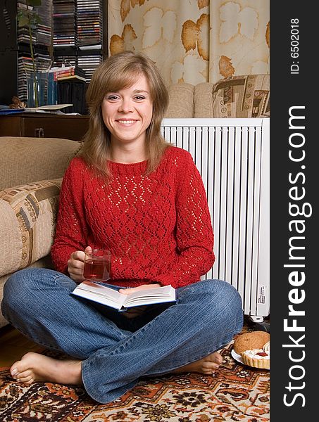 Woman sits on a carpet in a living room. Woman sits on a carpet in a living room