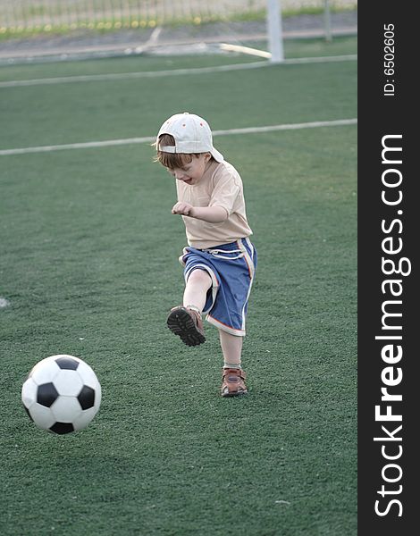 The kid hazardously playing football in stadium