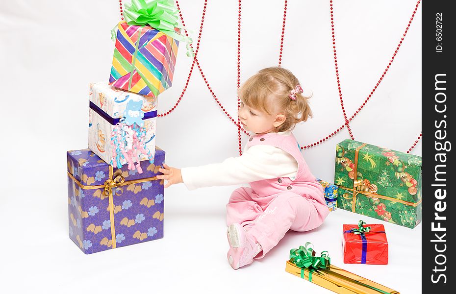 Happy infant with gifts in the decorated christmas box;