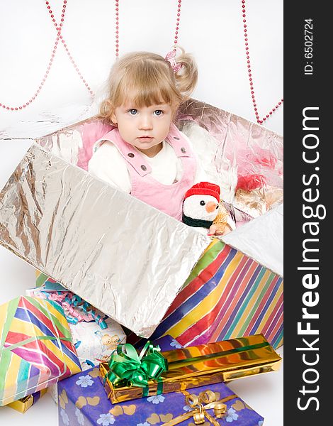 Happy infant with gifts in the decorated christmas box;