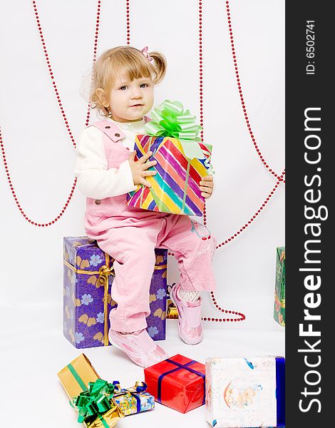 Happy infant with gifts in the decorated christmas box;