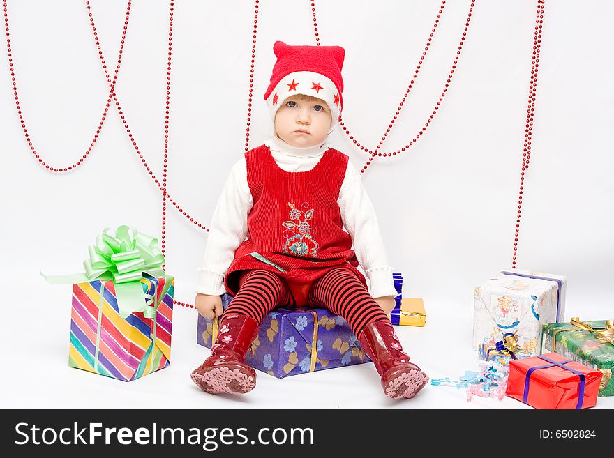 Happy infant with gifts in the decorated christmas box;