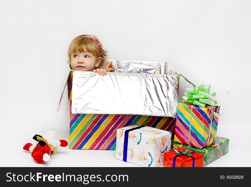 Happy infant with gifts in the decorated christmas box;