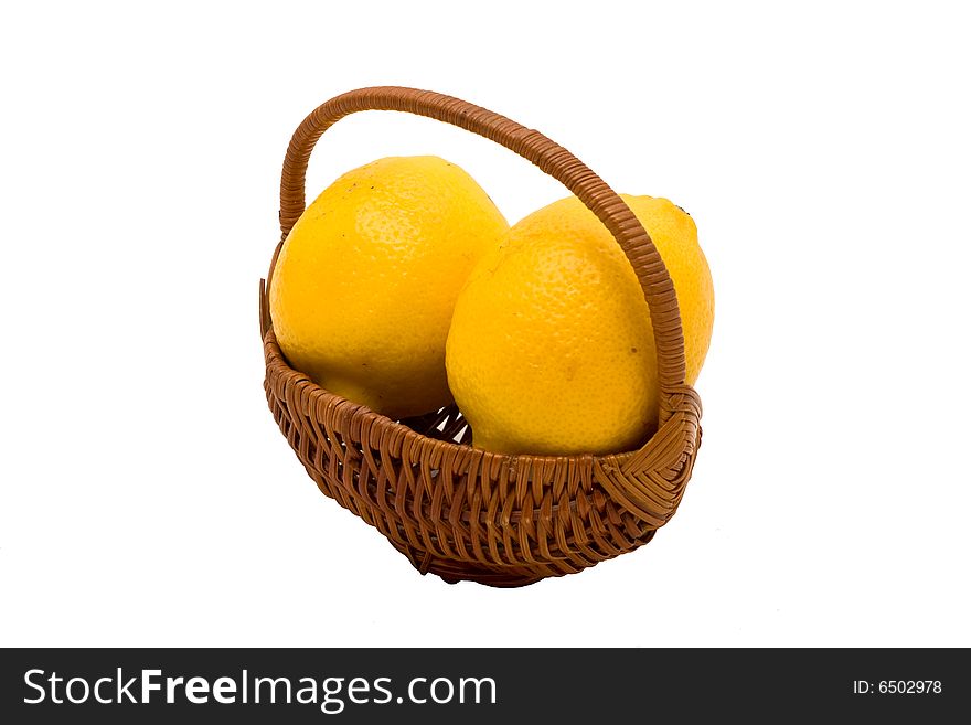 Two fresh yellow lemons  in small wicker basket on isolated white background. Two fresh yellow lemons  in small wicker basket on isolated white background