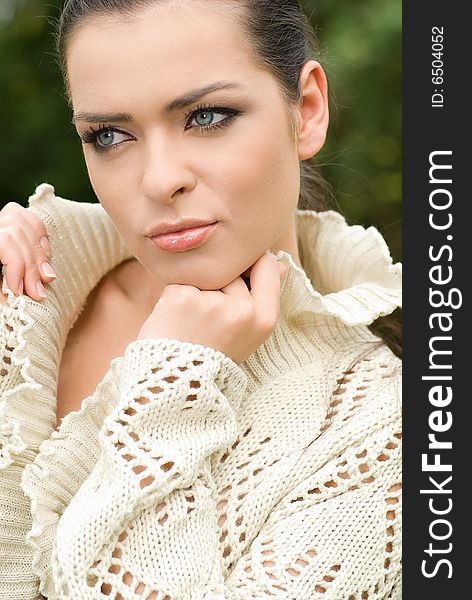 Portrait of beautiful woman in park. green background