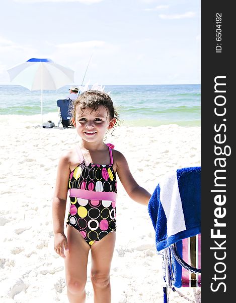 Beautiful little girl on the beach smiling with her swimsuit on enjoying her vacation. Beautiful little girl on the beach smiling with her swimsuit on enjoying her vacation.
