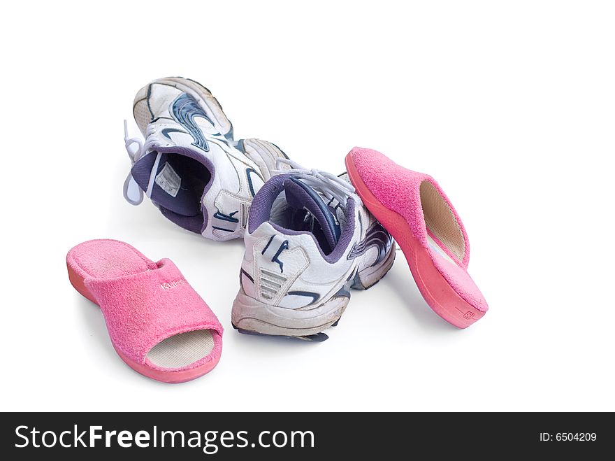 A pair of sneakers and pink slippers isolated on white