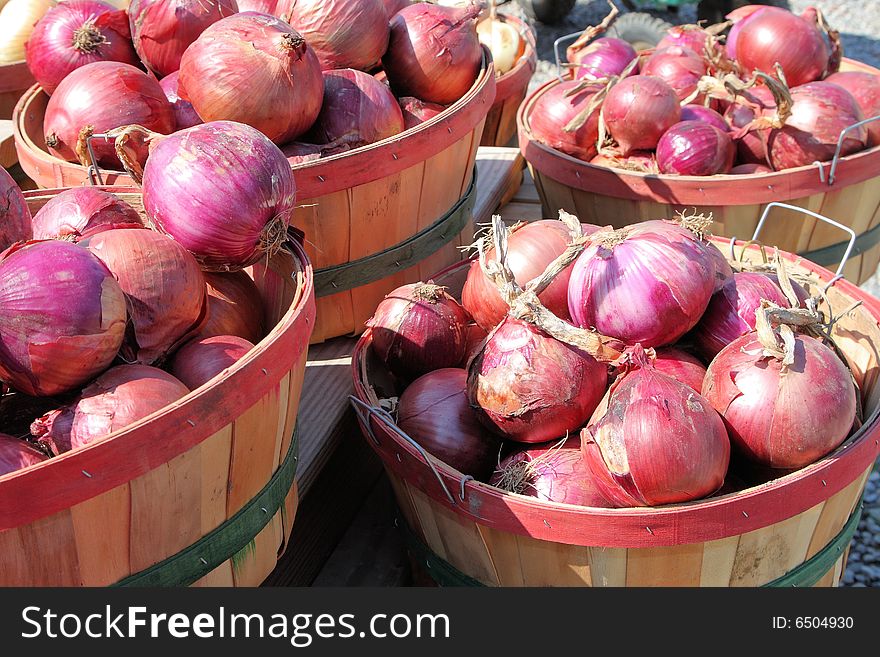 Bushels of fresh picked red onions at a roadside market