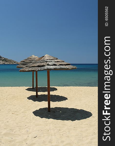 Row of straw umbrellas on exotic beach. Row of straw umbrellas on exotic beach.