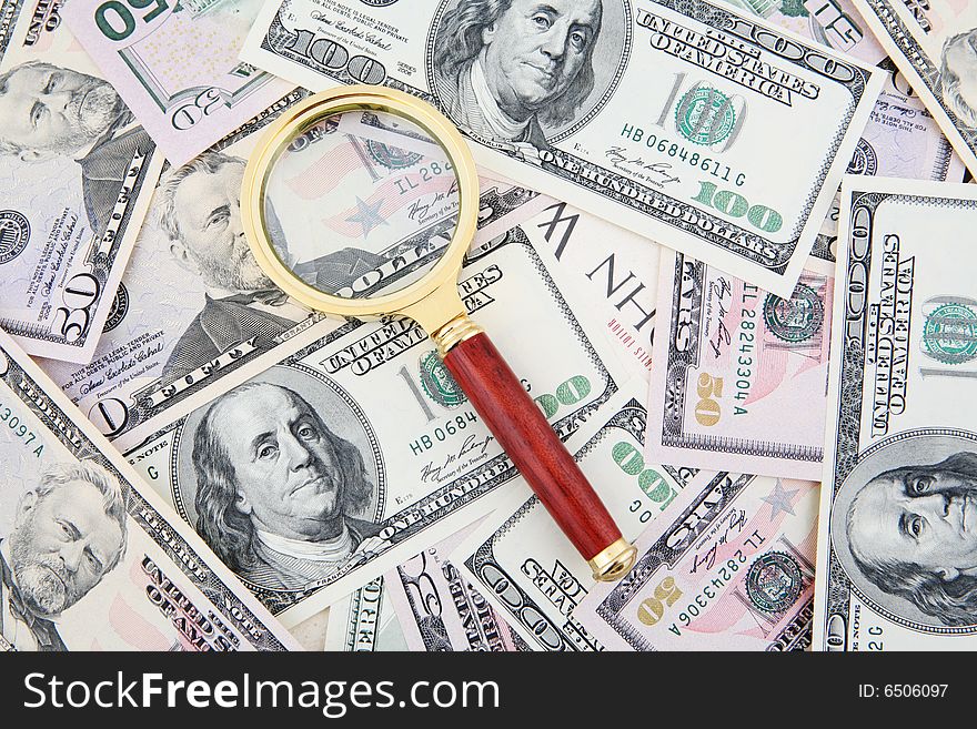 Magnifying glass shot over hundred and fifty US Dollars bills. Magnifying glass shot over hundred and fifty US Dollars bills