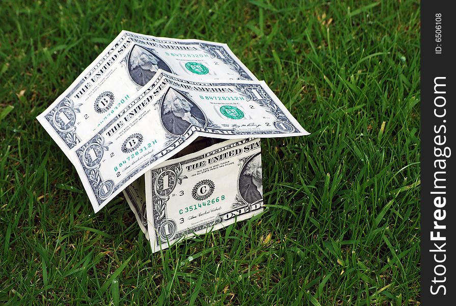 Conceptual image showing house shape made from US dollars on grass. Conceptual image showing house shape made from US dollars on grass