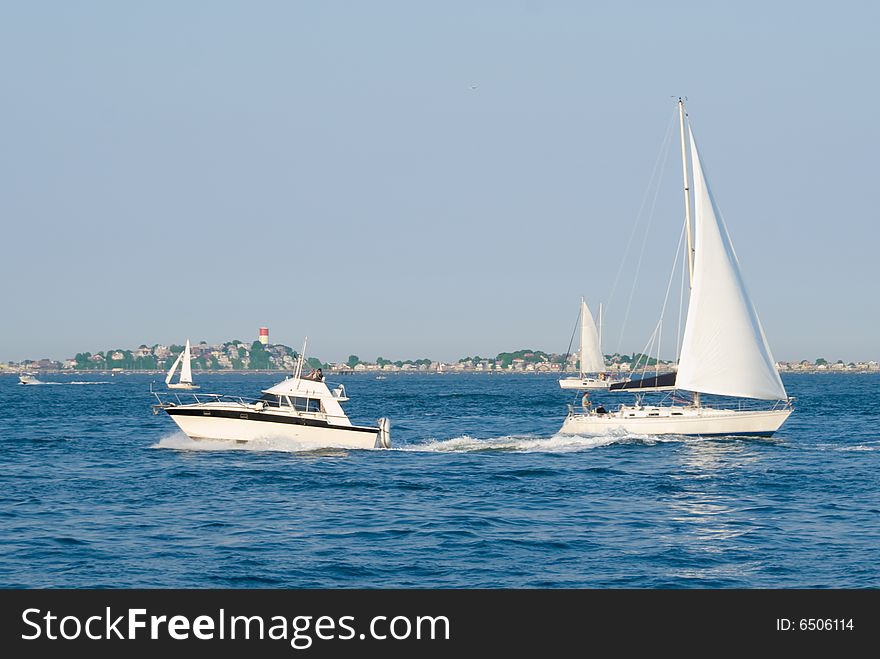 Motor and Sail boats passing in Boston Harbor on a beautiful summer day. Motor and Sail boats passing in Boston Harbor on a beautiful summer day