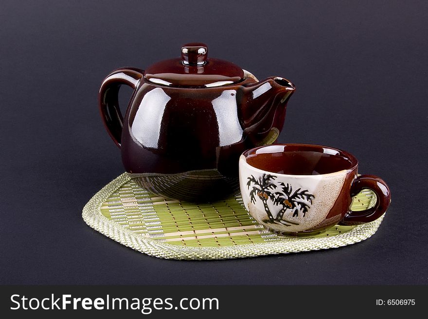 Composition of teapot and cups isolated on violet background