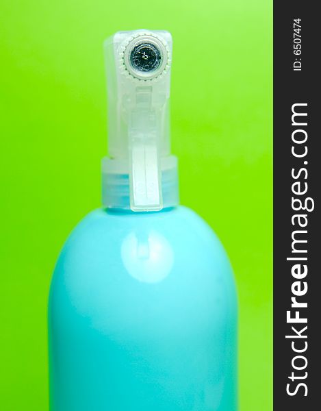 A spray bottle isolated against a green background