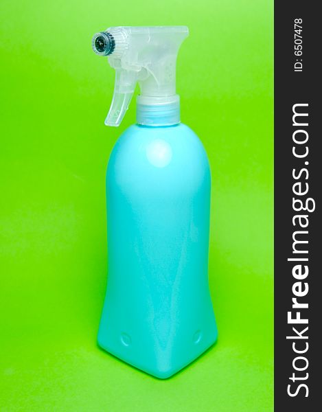 A spray bottle isolated against a green background