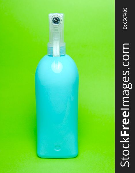 A spray bottle isolated against a green background