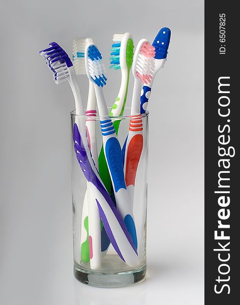 Five new toothbrushes in glass