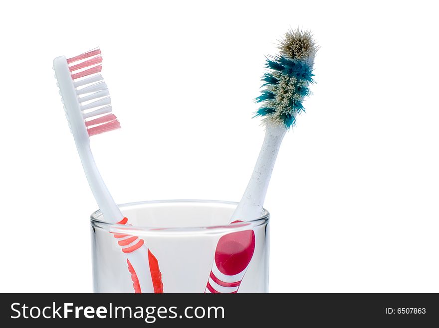 New and old toothbrushes in glass, isolated