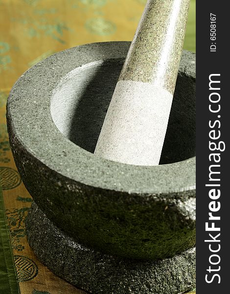 Mortar and pestle on a green silk background. Mortar and pestle on a green silk background