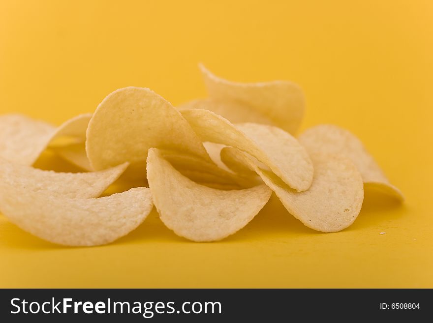 Chips close-up isolated on yellow background