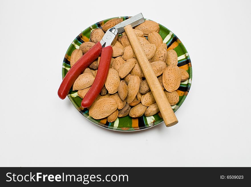 Almond seeds placed on a dish with hummer and clipper