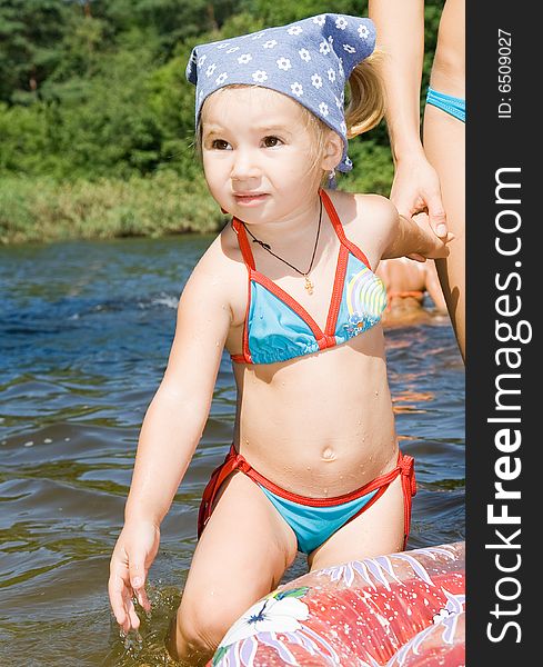 Little girl in river in summer
