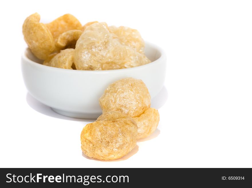 Fried pork rinds on a bowl on white background