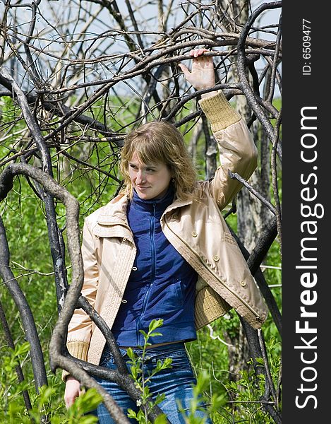 A view through the branches of a tree, focused on a pretty young teenage girl. A view through the branches of a tree, focused on a pretty young teenage girl