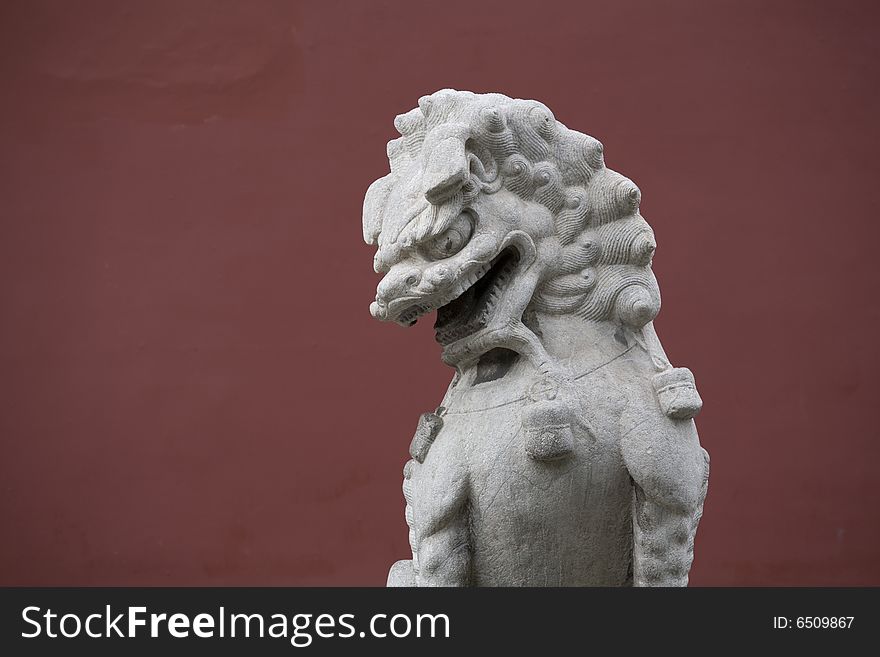 Stone sculpture lion at China，a deep red of background. Stone sculpture lion at China，a deep red of background