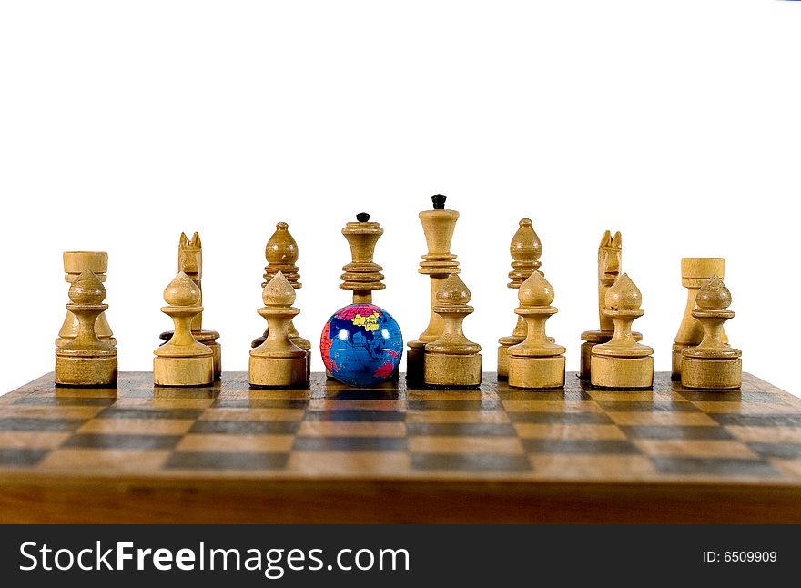 Small globe and wooden chess figures on an old chessboard