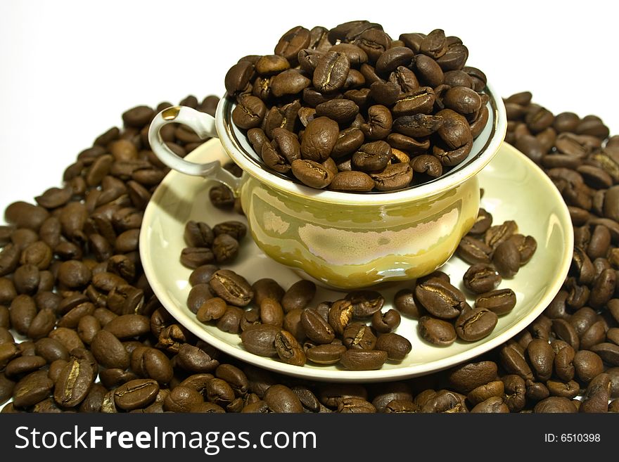 Cup of coffee in surroundings grains